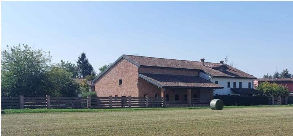 een groot bakstenen gebouw met een vat ervoor bij Canovetta Country House "Camelia" - nearby Cremona 