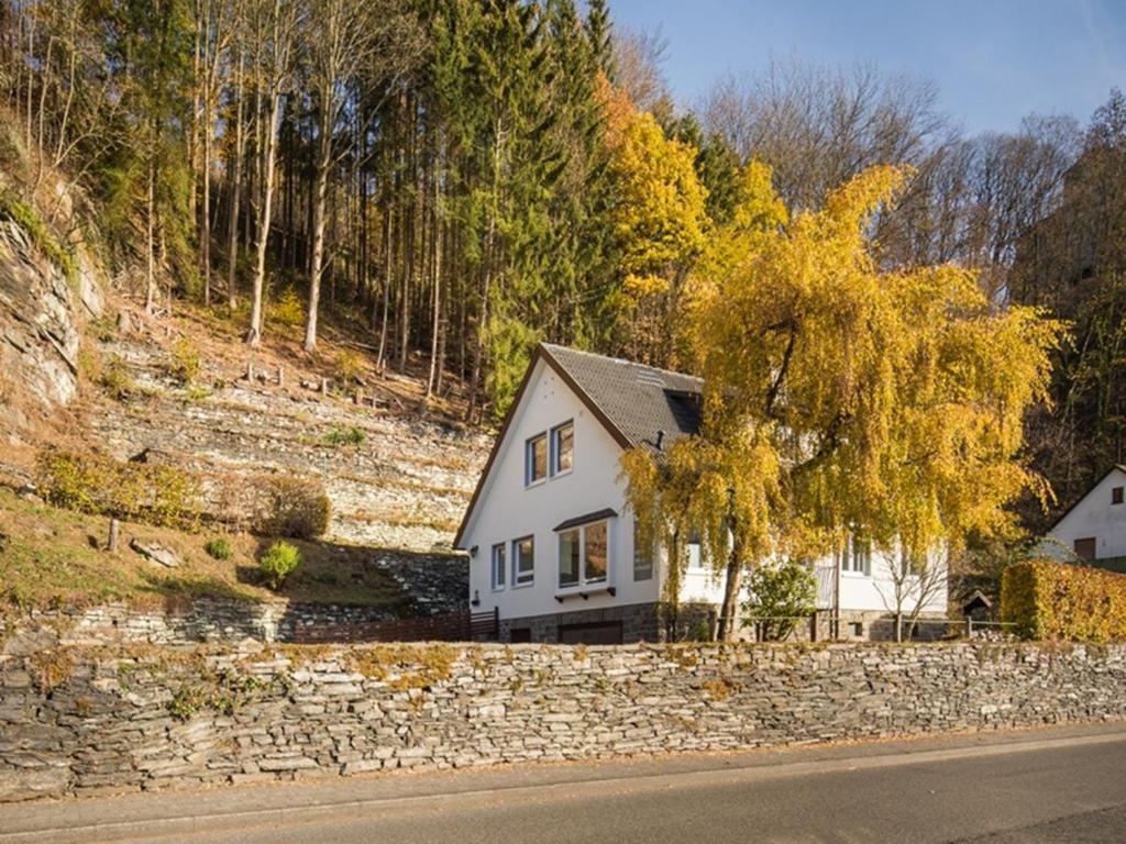 uma casa branca com uma parede de pedra e uma árvore em Zur Altstadt 2 em Monschau