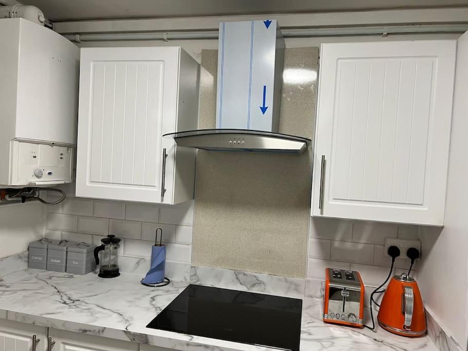 une cuisine avec des placards blancs et un comptoir dans l'établissement 2 bed Solihull near NEC Airport, JLR, Resort Wrld, à Solihull