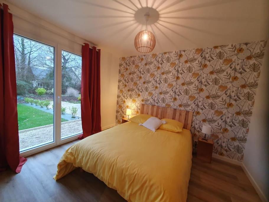 une chambre avec un lit et une grande fenêtre dans l'établissement Gîte Le Chardonneret 2 étoiles 4 personnes, Jugon les lacs, Côtes d'armor, à Saint-Igneuc