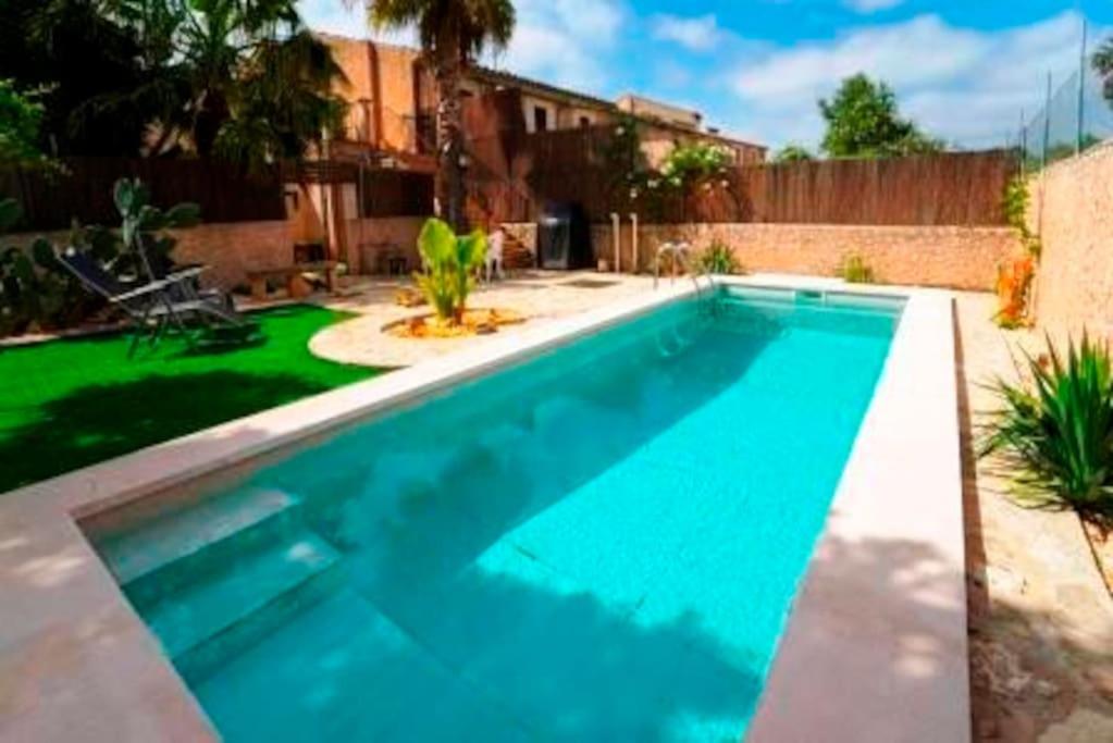 a large swimming pool in a yard with a house at Can Grau in Biniali
