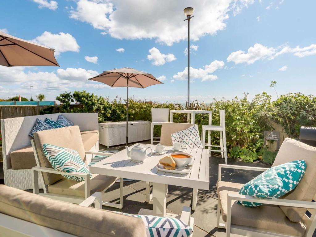 a patio with a table and chairs and an umbrella at 1 Bed in Hythe 89969 in Hythe