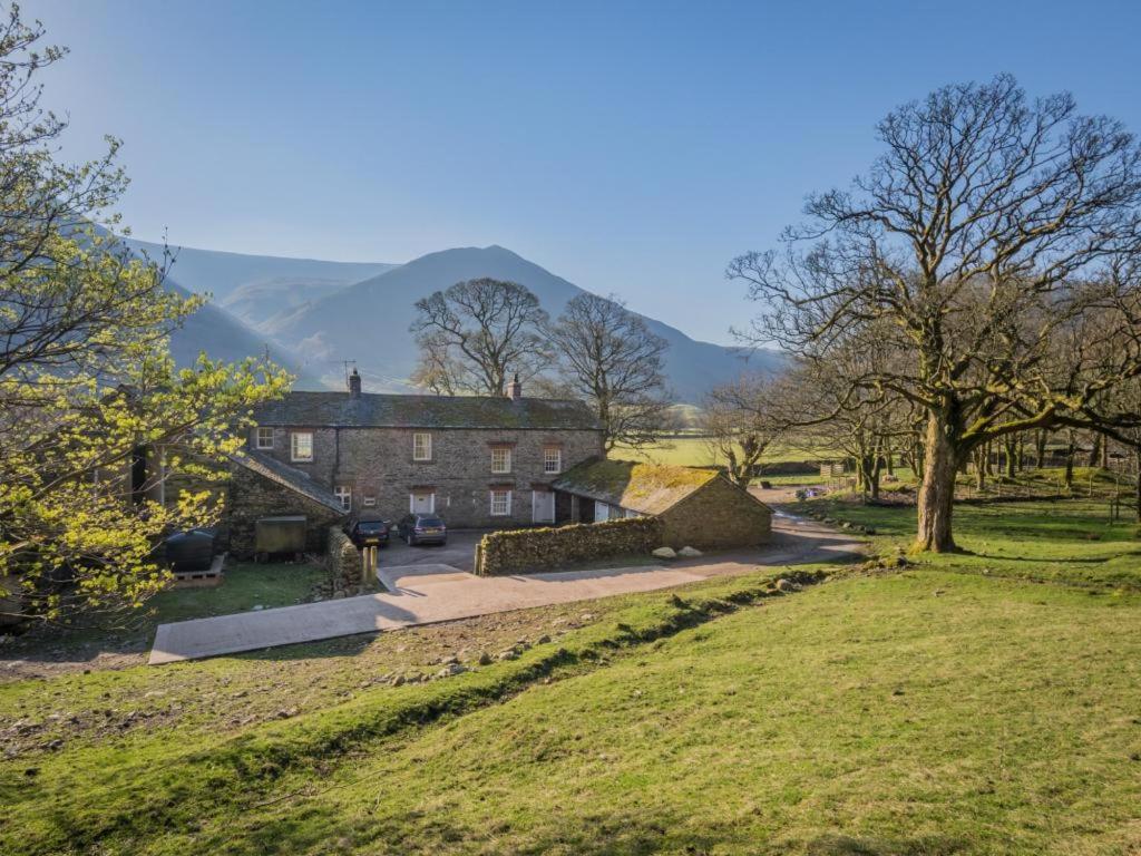 a house in a field with mountains in the background at 4 Bed in Patterdale SZ170 in Patterdale
