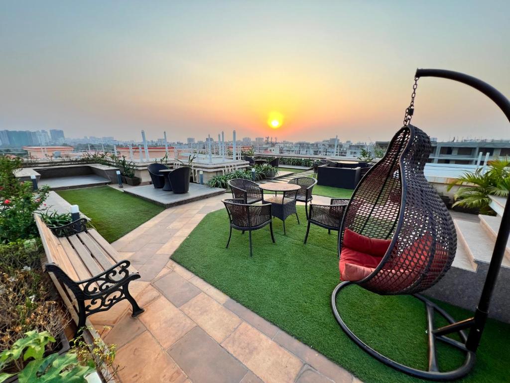 eine Terrasse mit einer Hängematte sowie einem Tisch und Stühlen in der Unterkunft Juhu Getaway with Rooftop Pad! in Mumbai