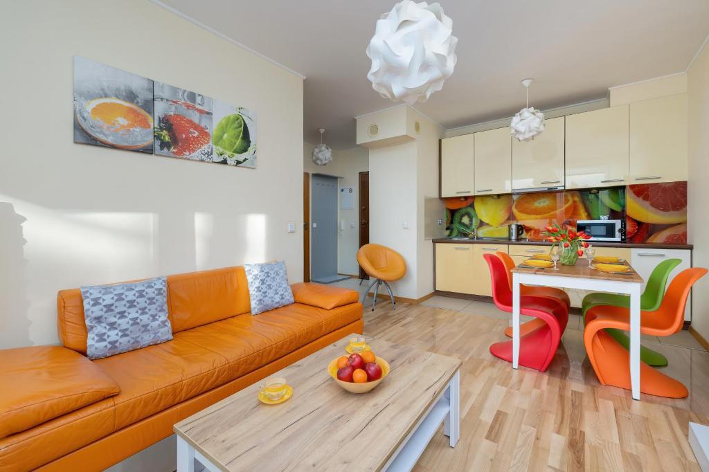 een woonkamer met een bank en een tafel bij Lilly Aquamarina SeaView by Rent like home in Międzyzdroje