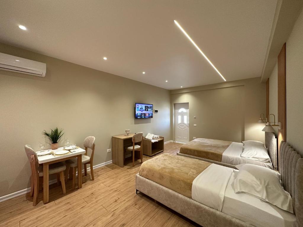 a hotel room with two beds and a table and a dining room at Arial Lofts in Vlorë