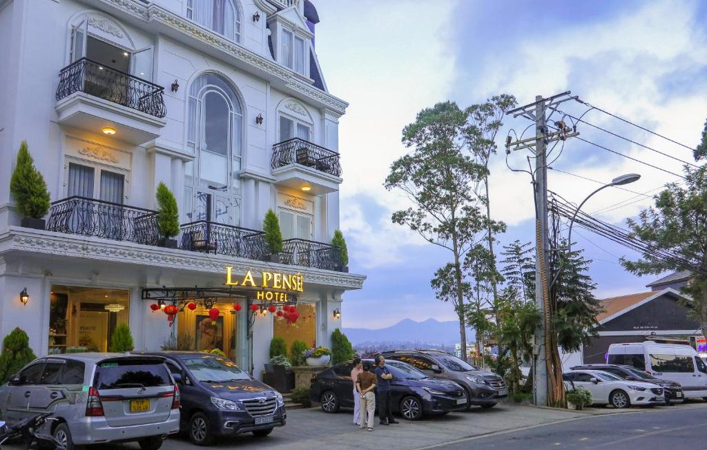 un edificio con coches estacionados frente a una tienda en La Pense'e Hotel - Dalat, en Da Lat