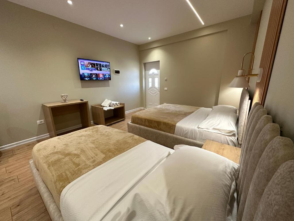 a hotel room with two beds and a flat screen tv at Arial Lofts in Vlorë