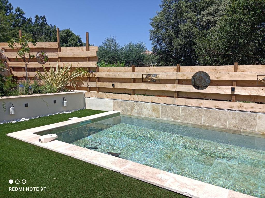 uma piscina num quintal ao lado de uma cerca de madeira em Patio de Lea (web) em Mons