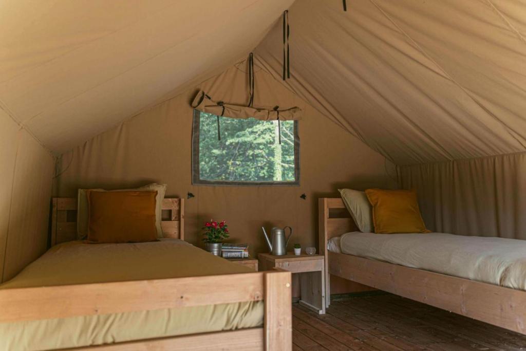 a bedroom with two beds in a tent at Ca Stella Camping del Monte San Giorgio in Meride