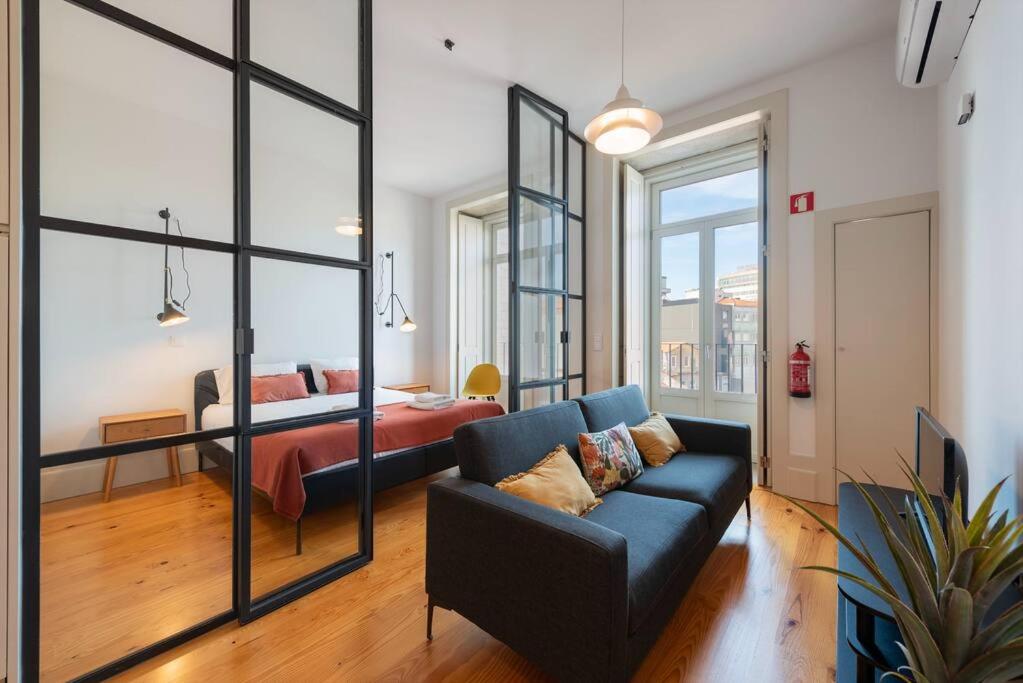 een woonkamer met een bank en een slaapkamer bij São Bento Bright Studio in Porto