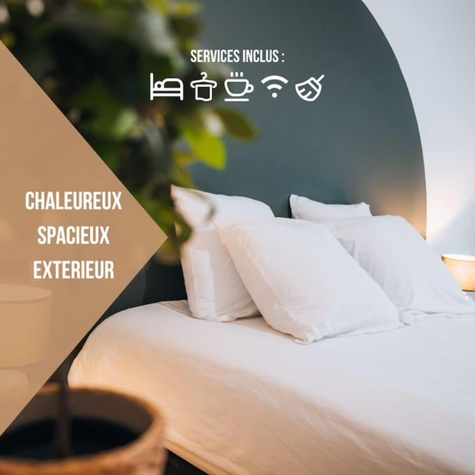 - un lit à baldaquin avec des oreillers blancs dans l'établissement Le Sainte-Hélène • Le Modernisme en Cœur de Ville, à Châteauroux