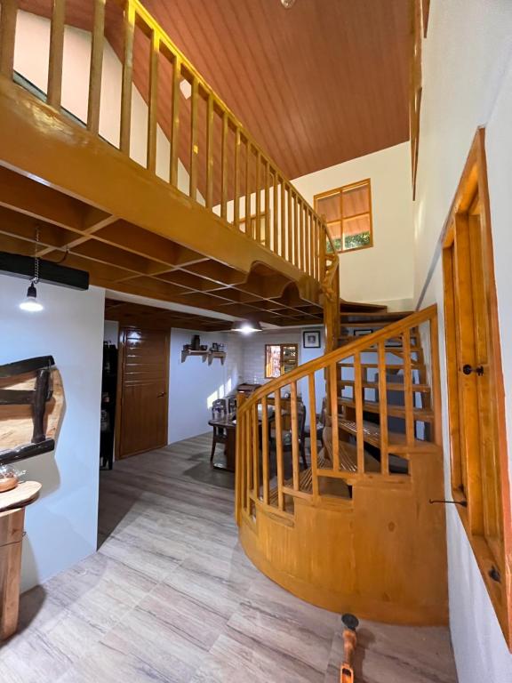 uma escada em espiral de madeira numa casa com pisos de madeira em The Forest Creek Cabin 