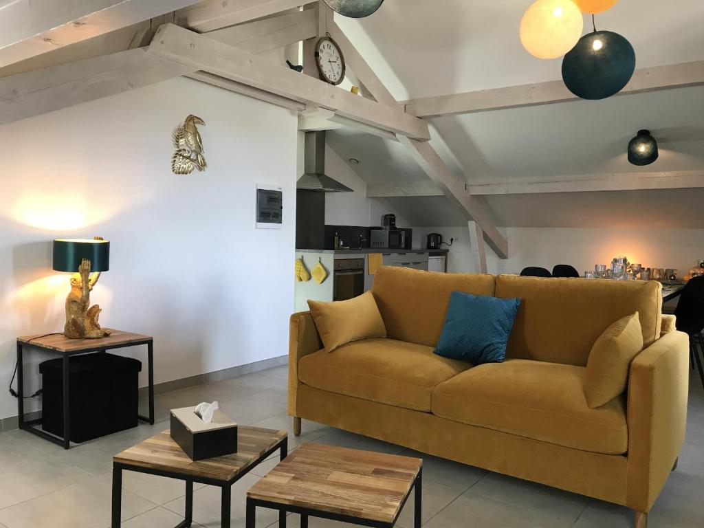ein Wohnzimmer mit einem Sofa und einem Tisch in der Unterkunft M48 *Marquer* T2 atypique Cranves-Sales in Cranves-Sales