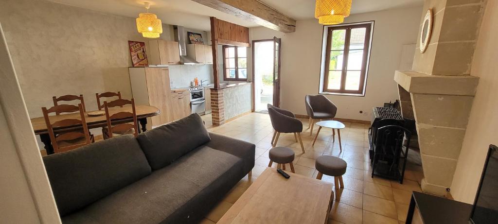 un salon avec un canapé et une table et une cuisine dans l'établissement Agréable Gîte proche du ZOO de Beauval et des chateaux3, à Selles-sur-Cher
