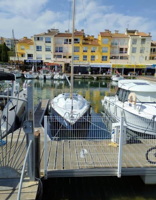 un groupe de bateaux amarrés dans un port de plaisance comportant des bâtiments dans l'établissement Séjour voilier port de Gruissan, à Gruissan