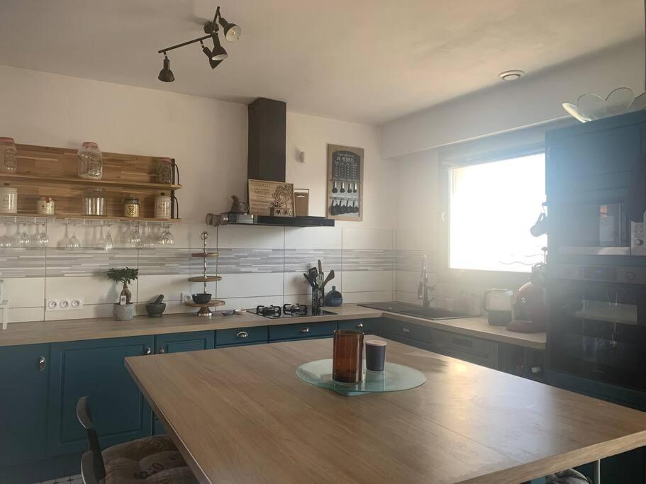 une cuisine avec une table en bois et une fenêtre dans l'établissement Maison a étages bord de mer, à Notre-Dame-de-Monts
