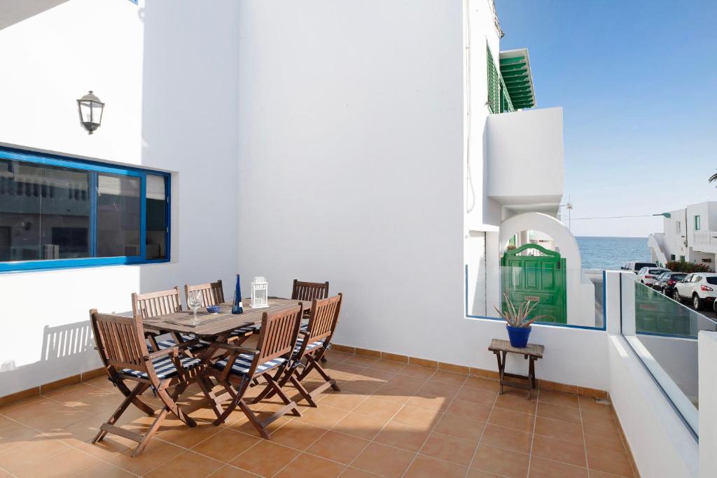 a dining room with a table and chairs on a balcony at La Chinija in Playa Honda