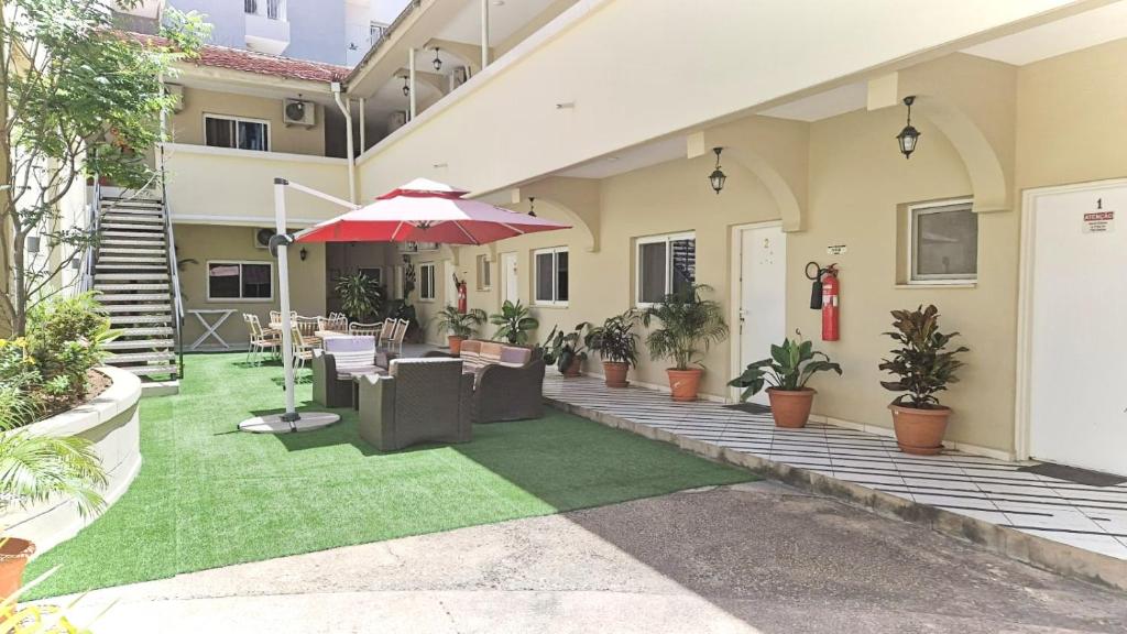 patio z krzesłami i parasolem w obiekcie CASA NATALIA - Guesthouse w mieście Luanda