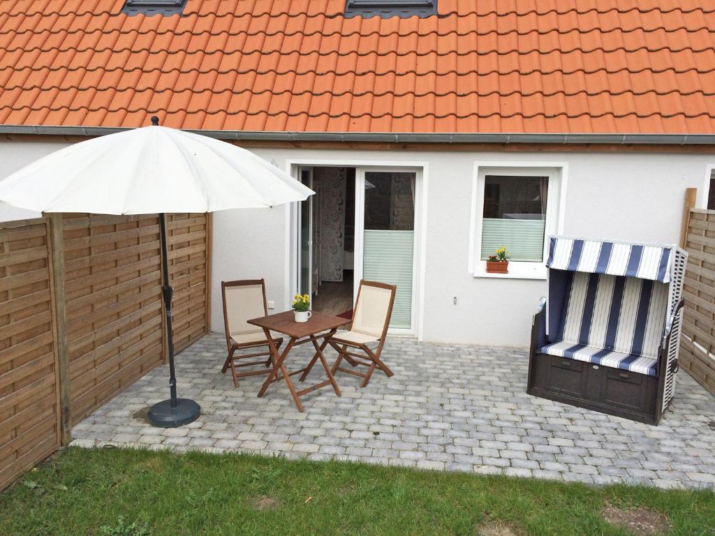 un patio con mesa, sillas y sombrilla en Lindenhof, en Kleinwessek