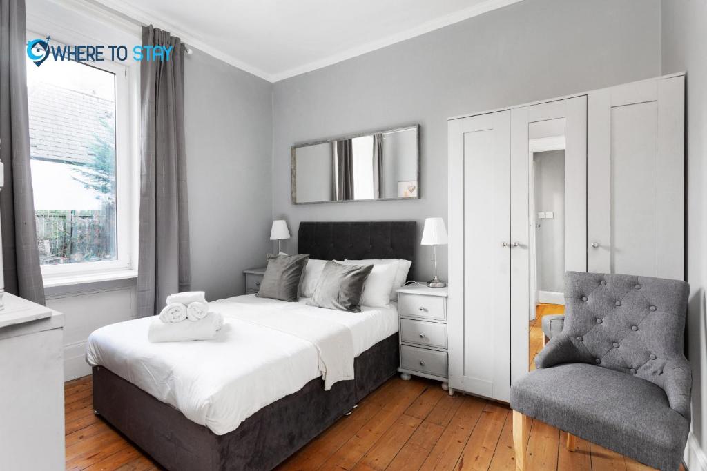 a bedroom with a bed and a chair at Marvellous 2 bed apartment Edinburgh in Edinburgh