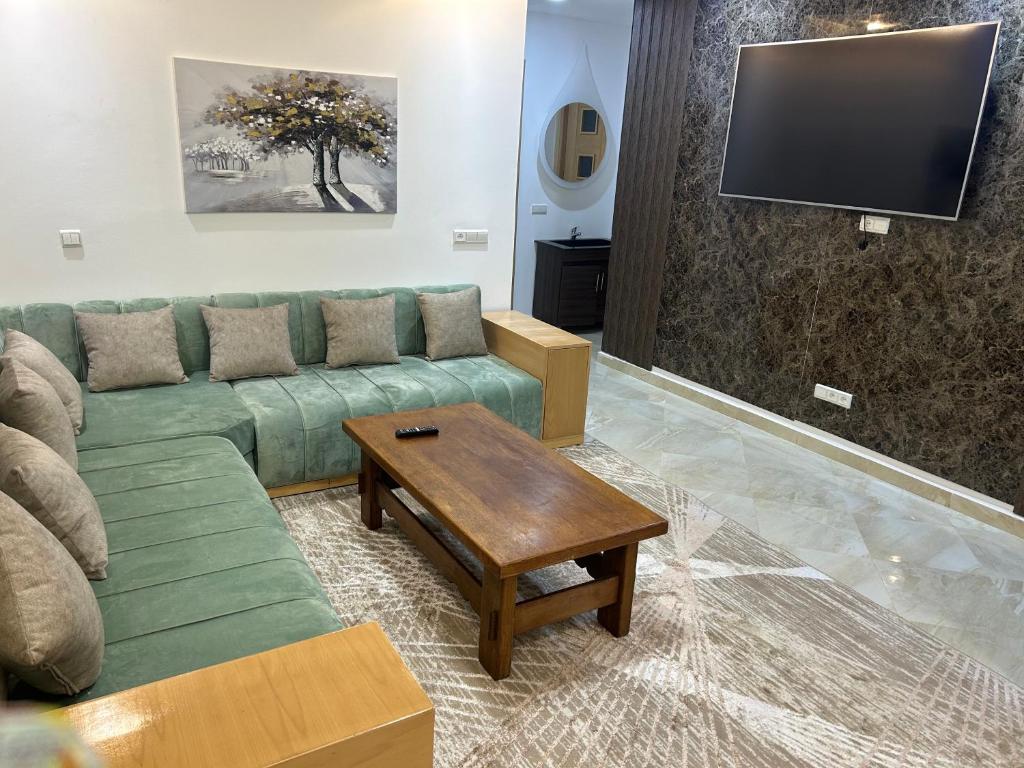 a living room with a green couch and a tv at Appt nice stay Oujda in Oujda