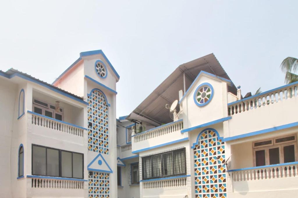 a building with a clock on the side of it at Calangute Cosy 1 bhk Apartment in Calangute
