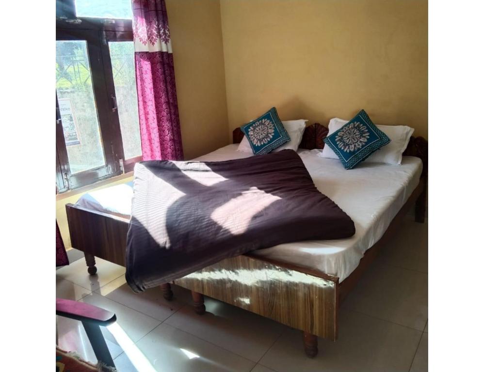 a bedroom with two beds and a window at Morning Calm Homestay, Joshimath in Joshīmath