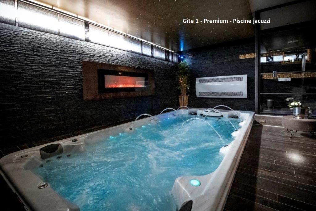 uma grande banheira na casa de banho com televisão em Suite Wellness em Sprimont
