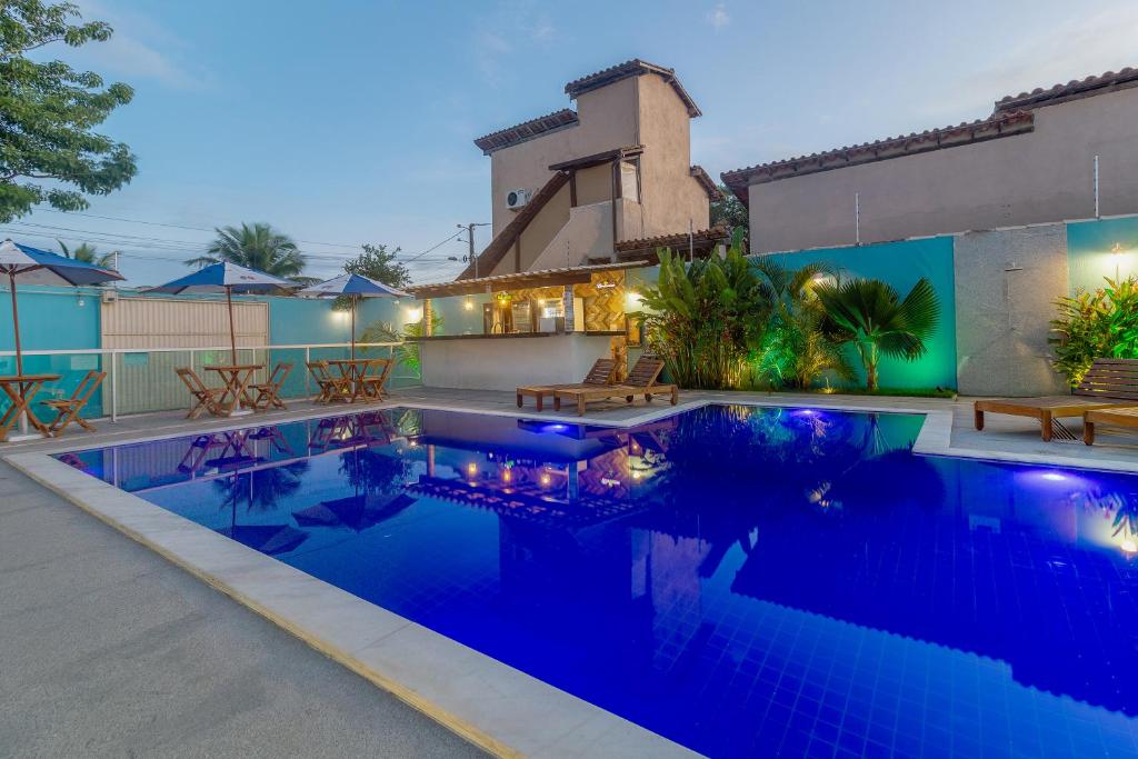 una piscina de agua azul frente a una casa en Hotel Pousada Tribalista, en Arraial d'Ajuda