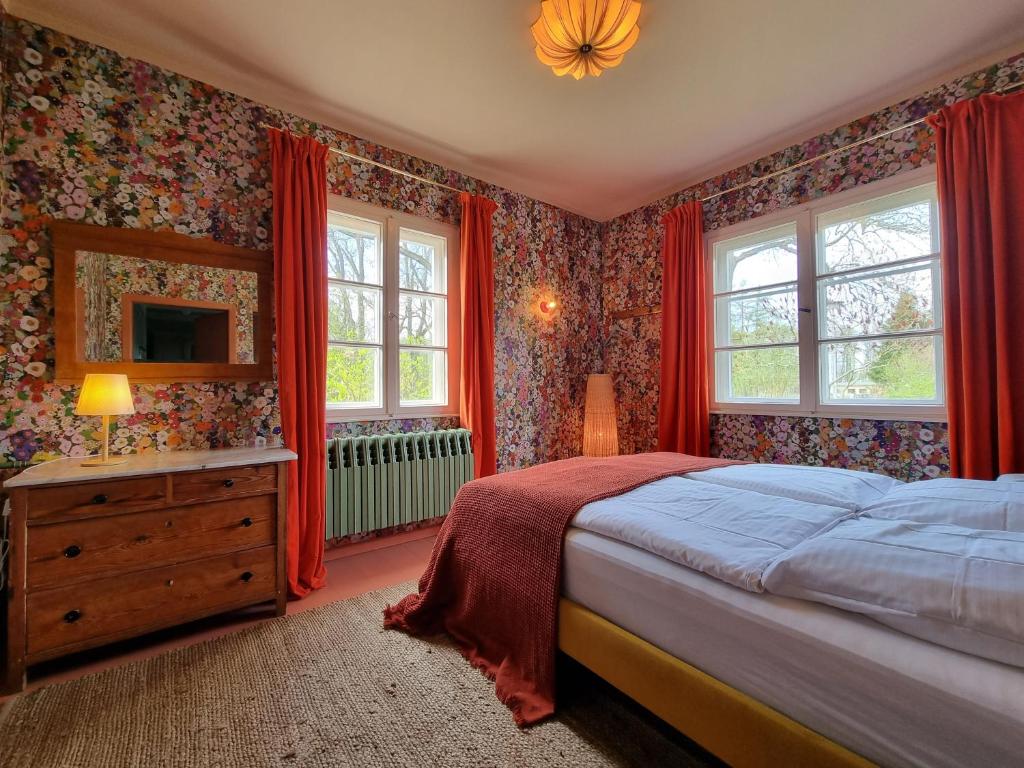 - une chambre avec un lit, une commode et des fenêtres dans l'établissement Pommernhaus Forsthaus Rieth am See, Sauna, Kamin, Ruderboot, à Rieth