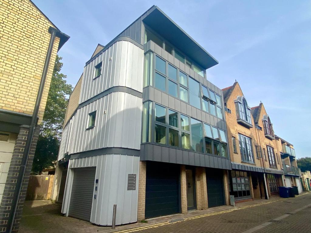 a tall building with glass windows on a street at Your Space Apartments - Cambridge Place in Cambridge