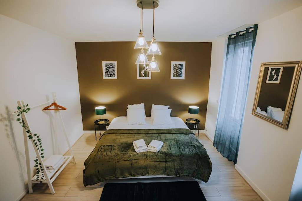 a bedroom with a bed with two books on it at Le Bertrand • Le Raffinement en Cœur de Ville in Châteauroux