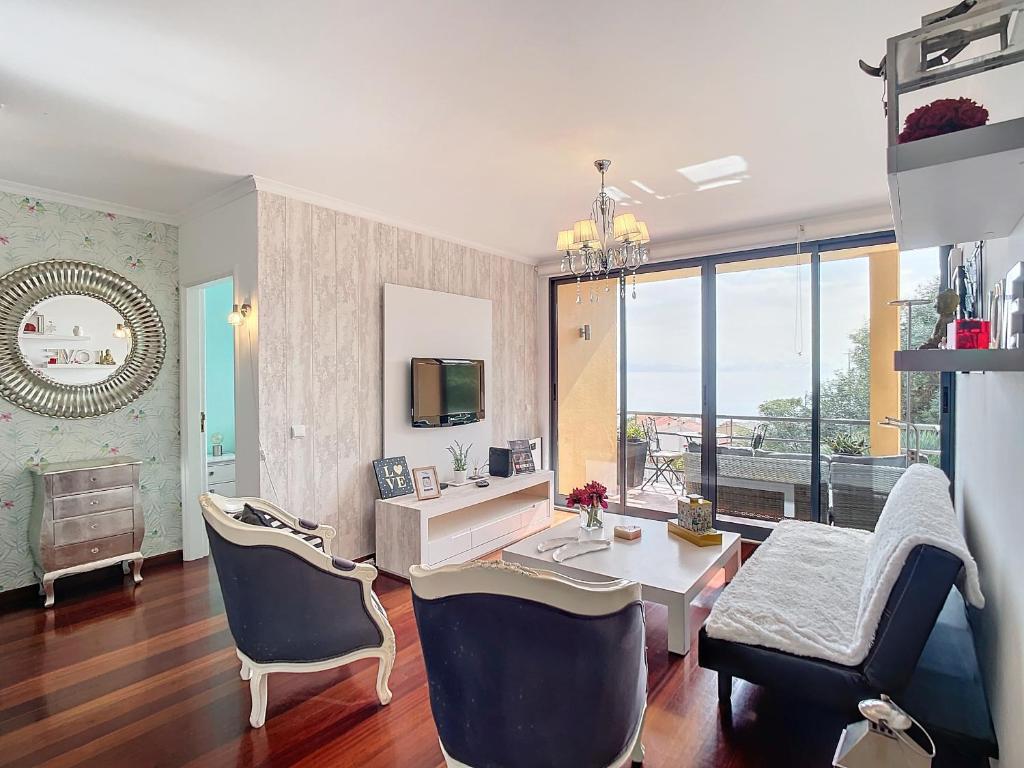 een grote woonkamer met een bureau en stoelen bij Vista Mar by Atlantic Holiday in Caniço