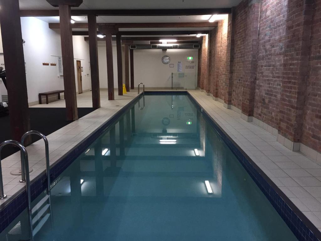 a swimming pool with blue water in a building at Frisco Apartments in Brisbane