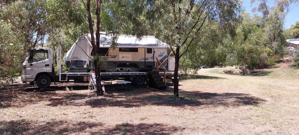 冈尼达RV Caravan in Rural Setting on Edge of Town close to AgQuip的一辆卡车,一辆有野营车停在田野里
