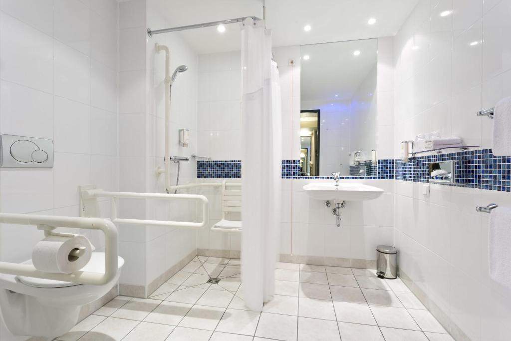 a white bathroom with a toilet and a sink at Holiday Inn Express Singen, an IHG Hotel in Singen