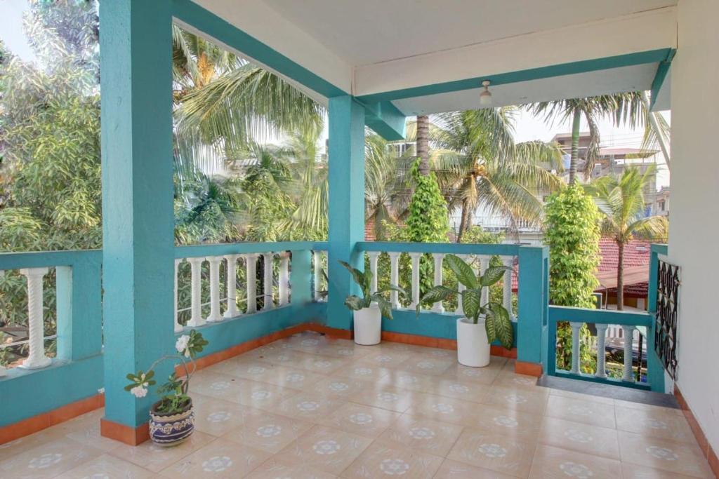 a balcony with blue walls and plants and trees at Comfort Holiday Home in Baga