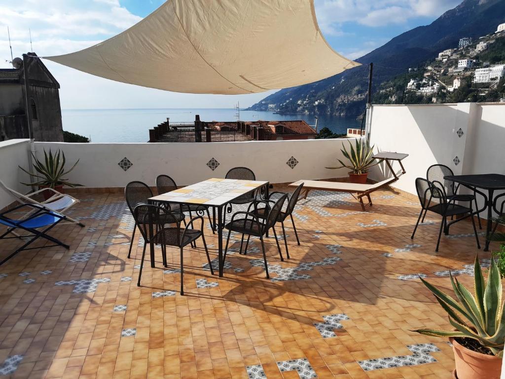 eine Terrasse mit Tischen und Stühlen auf einem Gebäude in der Unterkunft Casa Sebastian A in Vietri