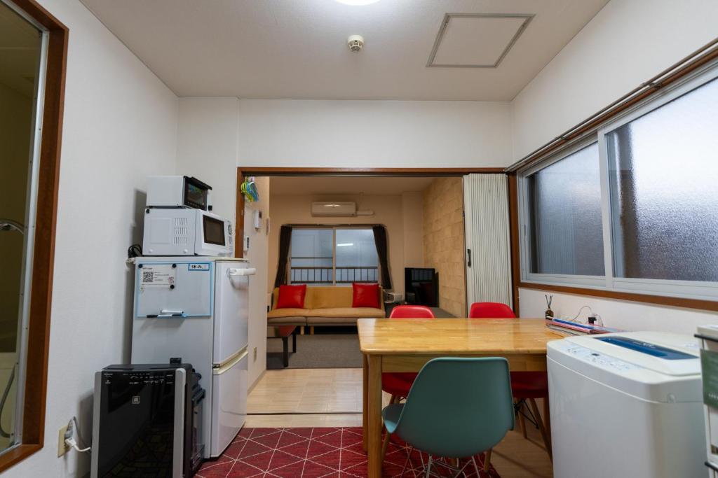 uma cozinha com uma mesa e um frigorífico em Almaz Place #205 em Sapporo