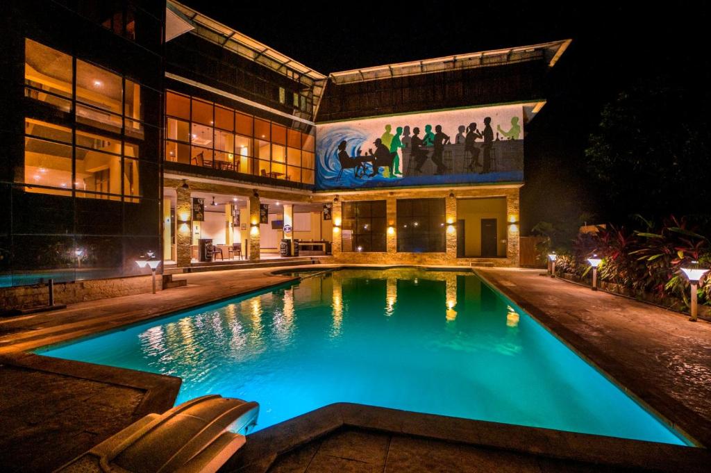 a swimming pool in front of a building at night at Silvanus Forest Retreat, Alibaug in Alibaug