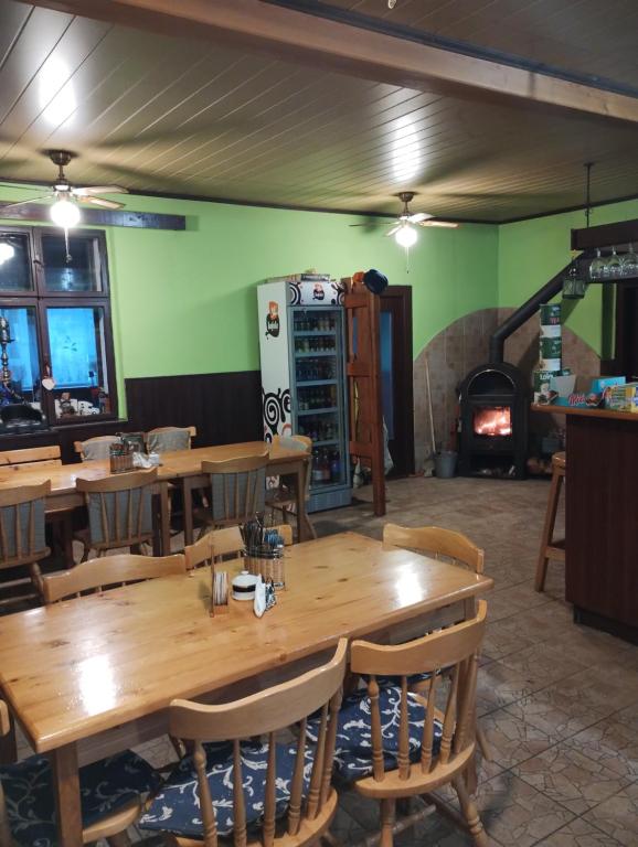 a dining room with wooden tables and a fireplace at Prázova Bouda in Dobré