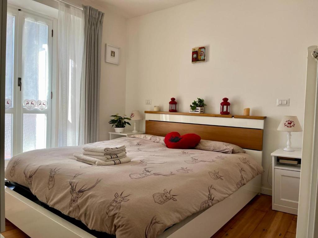 sypialnia z łóżkiem z 2 czerwonymi poduszkami w obiekcie Il nido di Curlo w mieście Chiesa in Valmalenco