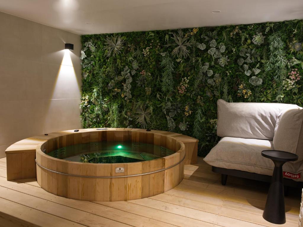 un soggiorno con una grande vasca in legno con sedia di Atypik Hotel a Clichy