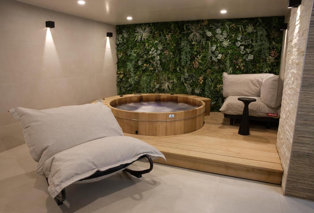 a spa room with a bath tub and a chair at Atypik Hotel in Clichy