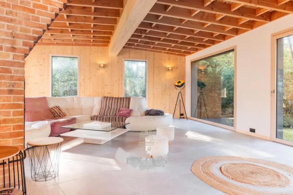 ein Wohnzimmer mit einem Sofa und einem Tisch in der Unterkunft Villa proche golf du Touquet in Cucq