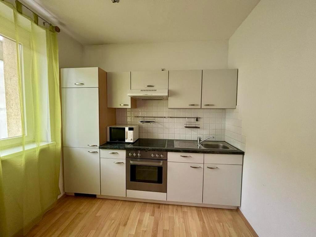 a kitchen with white cabinets and a white refrigerator at ADSA Apartment Linz in Linz