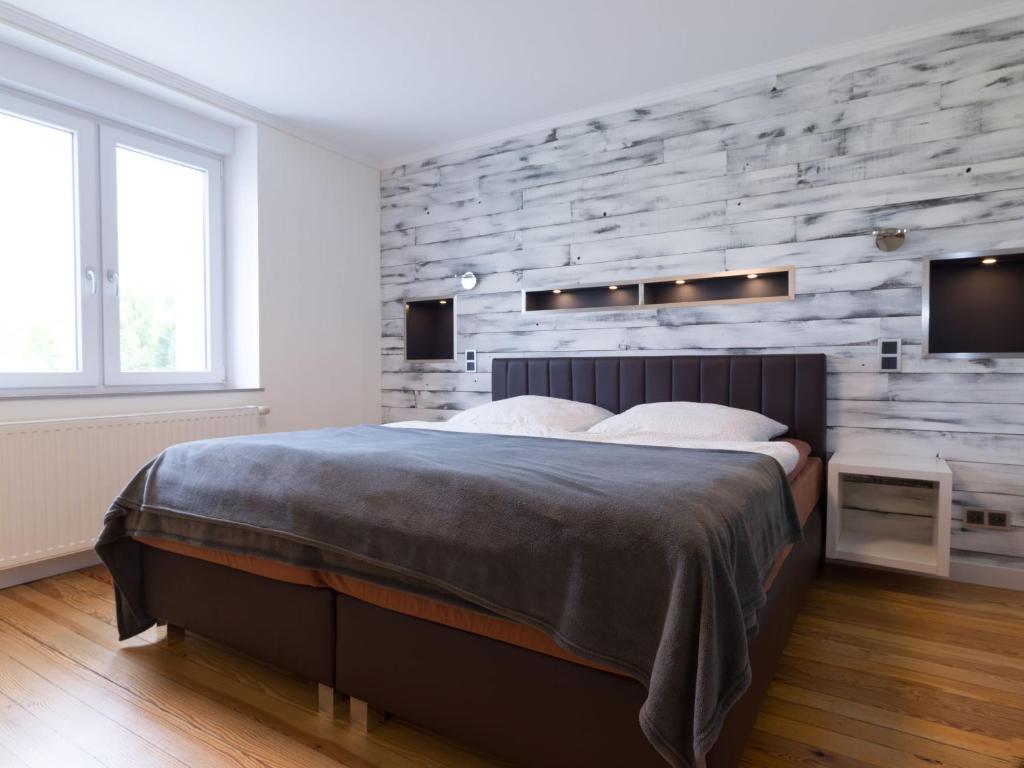 - une chambre avec un grand lit et un mur en pierre dans l'établissement Ferienwohnung direkt an der Nied, 