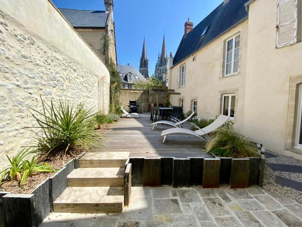 drewniany chodnik z ławkami i budynek w obiekcie BAYA HOUSE - Histoire et Confort w mieście Bayeux