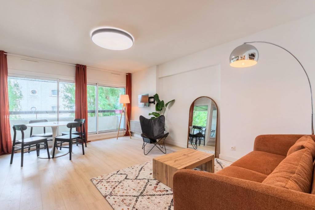 uma sala de estar com um sofá e uma mesa em Spacious apartment with balcony and parking em La Madeleine